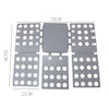 A gray magic clothes folding board with multiple circular holes for organizing t-shirts.