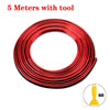 A coil of red flexible car interior trim strips with a tool.