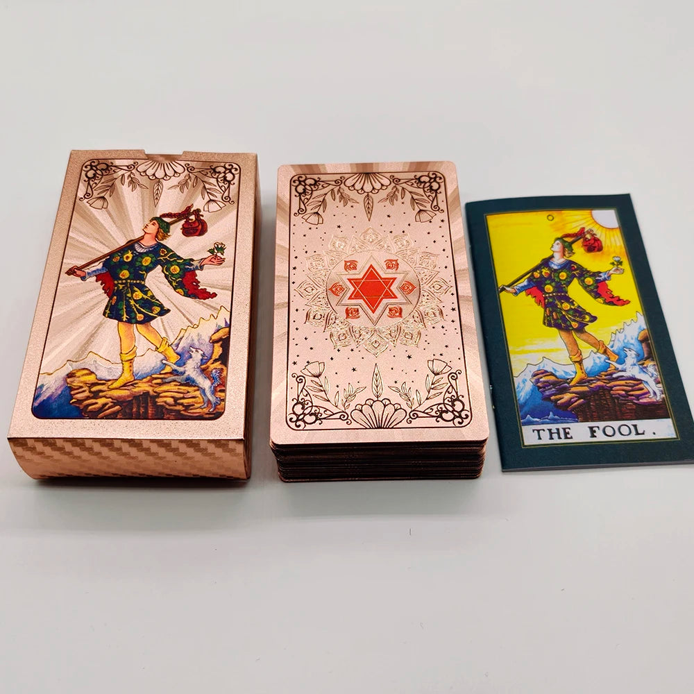 A set of gold foil tarot cards and guidebook featuring an illustration of a figure in historical attire.