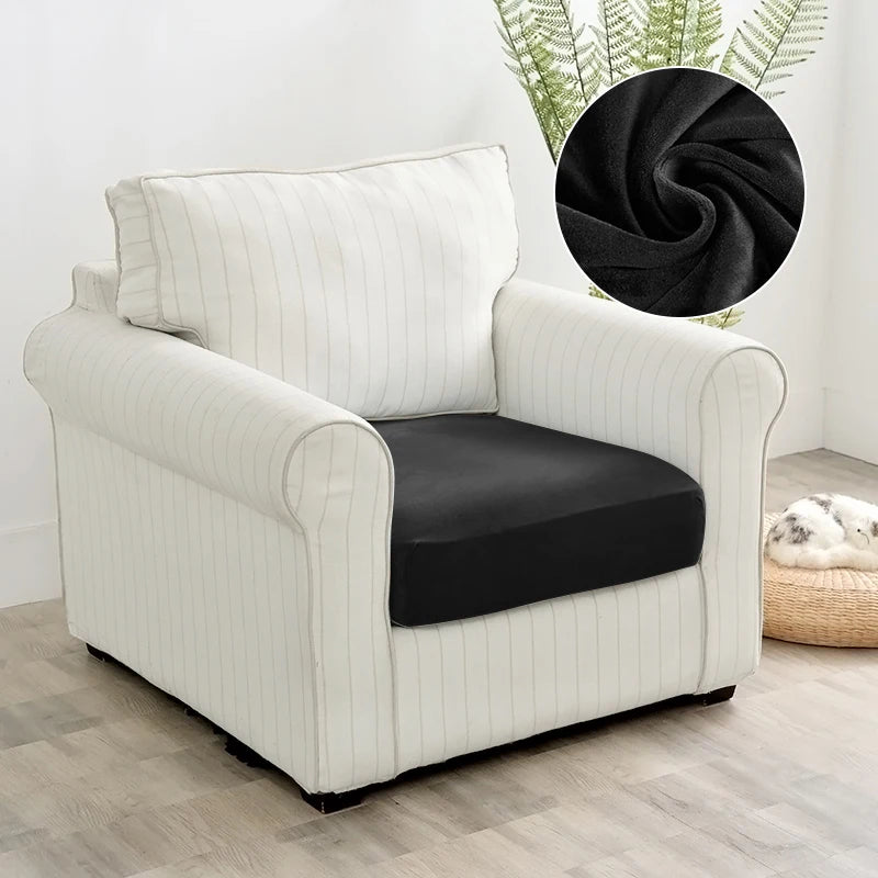 A cream-colored upholstered armchair with a black seat cover and vertical stripes sits on a light wood floor.