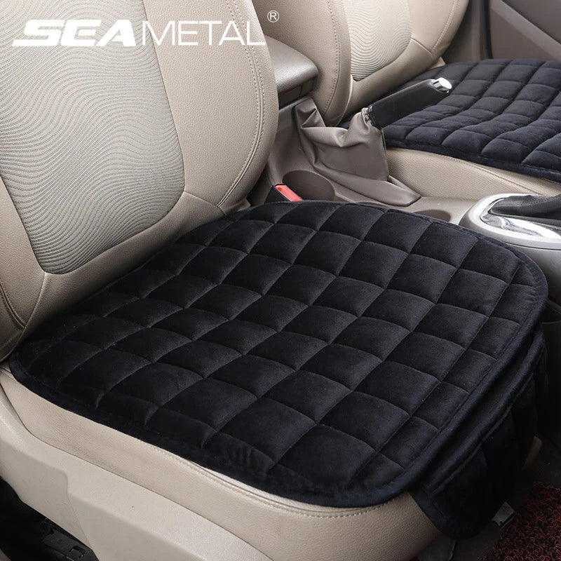A black quilted car seat cover with anti-slip backing is shown in a light beige vehicle interior.