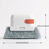 A white multi-purpose crevice cleaning brush with an orange tip resting on a gray foam surface.