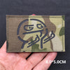 A close-up of a camouflage tactical patch featuring a stylized national flag design on a dark fabric.