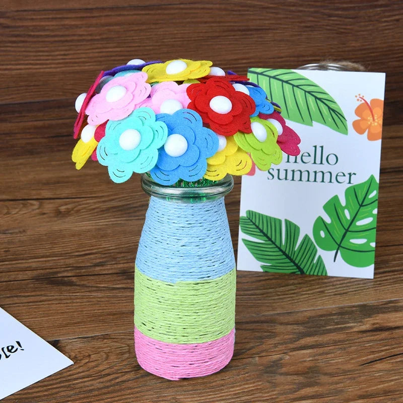 A colorful bouquet of felt and button flowers in various shades of pink, blue, yellow, and red displayed in a glass vase.