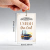 A vertical card with Arabic calligraphy and text for Umrah Dua, held by a hand.