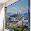 A modern window featuring a magnetic mosquito net with blue LED lighting, overlooking an urban landscape.