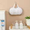 A white mesh laundry bag with a hanger is displayed on a wall, next to a washing machine.