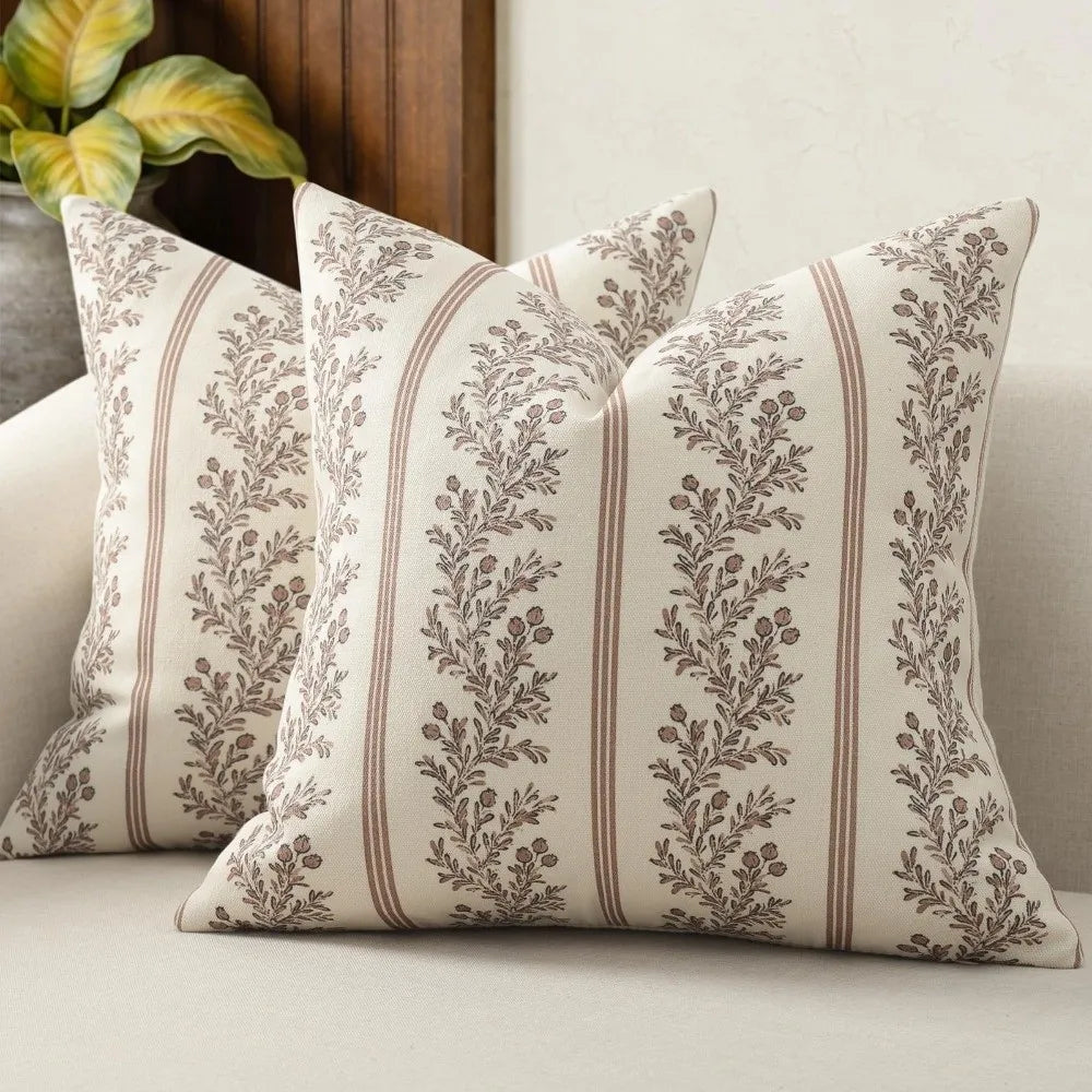 A beige throw pillow cover with vertical stripes featuring a muted gray floral pattern.