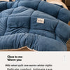 A deep blue milk velvet quilt blanket is shown draped on a bed, emphasizing its soft texture and warm comfort.
