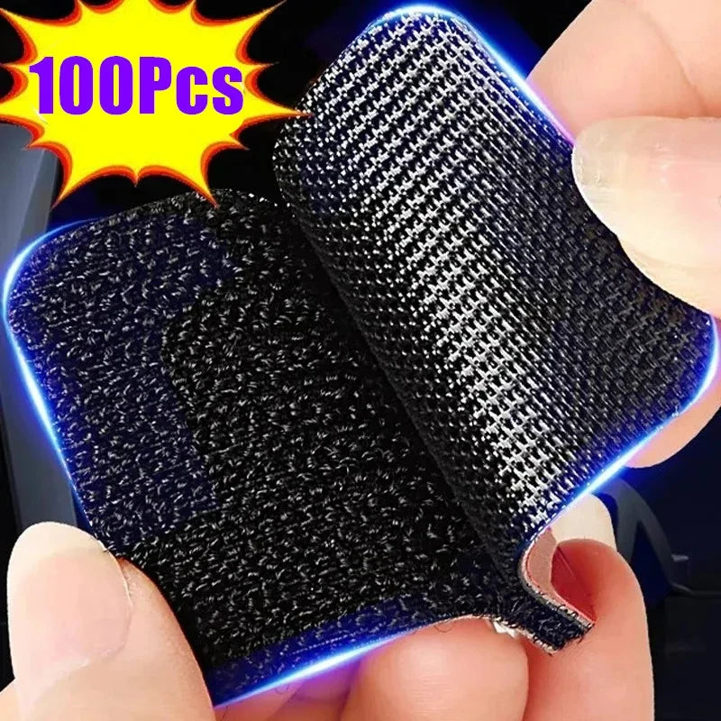 A close-up of a black double-sided adhesive carpet and mat fixing patch, showing its texture and blue glow against a hand.