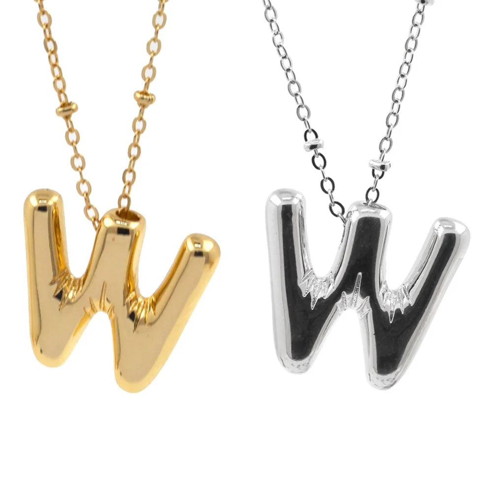 A pair of gold and silver initial letter pendant necklaces, one W and one M.