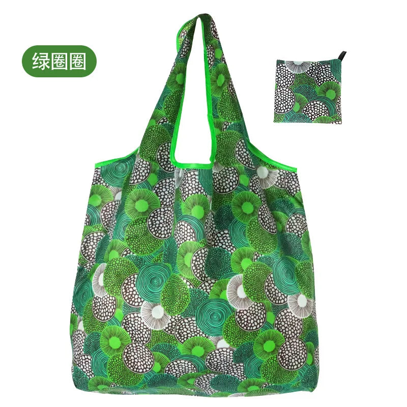 A green reusable shopping tote bag featuring a dense pattern of various green and white leaves and circular shapes.