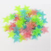 A pile of 100 luminous star-shaped wall stickers in various pastel colors like pink, blue, and green.