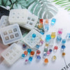 White silicone molds filled with colorful crystal ball beads and various gemstone shapes on a white background.