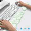 A set of translucent green cloud-shaped ergonomic wrist rests for a keyboard and mouse are shown next to a laptop.