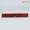 A rectangular piece of brown leather used as an acoustic guitar bridge saddle.