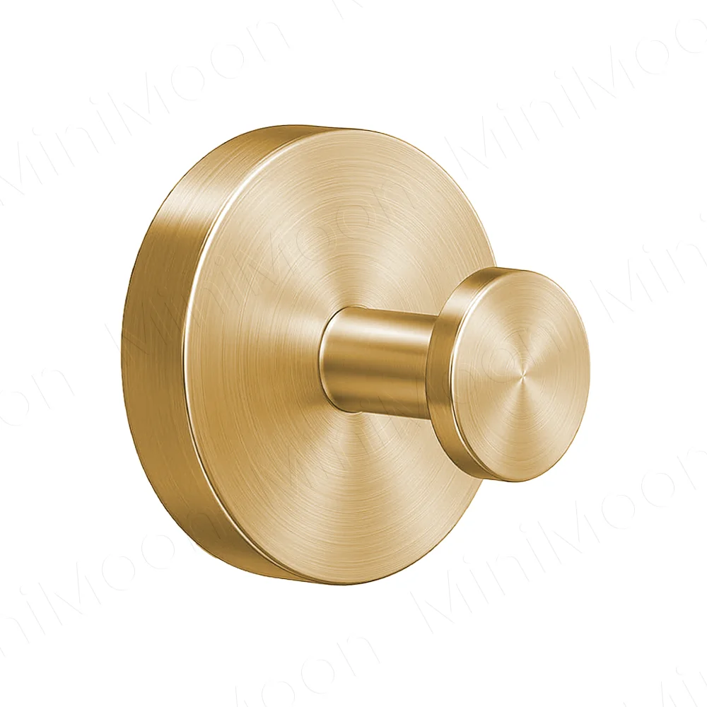 A round, brass-toned towel hook with a suction cup design mounted on a circular plate.