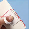 A hand holds a white sewing guide template with red stitching, demonstrating a precision stitch technique.