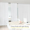 White privacy divider with light filtering fabric used in a room setting.