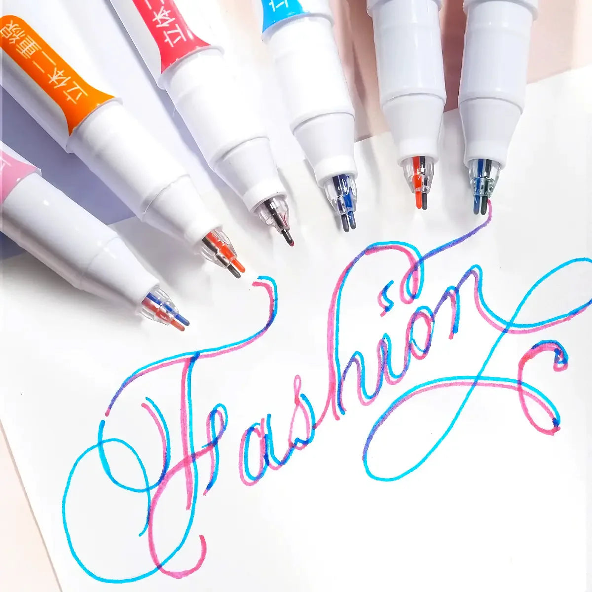 A set of six dual-color fluorescent marker pens with white and colored tips are displayed on a white background.