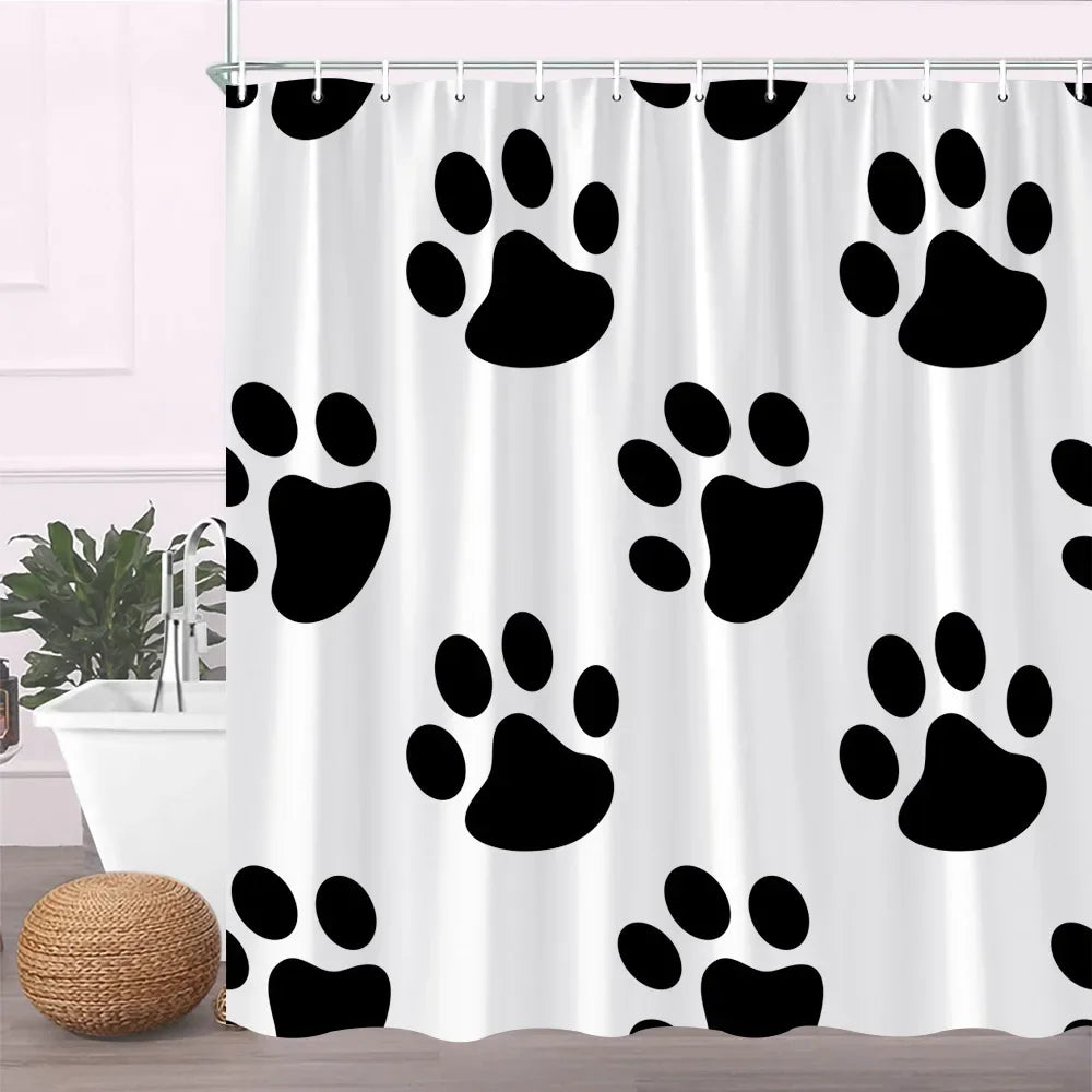 A white fabric shower curtain featuring a repeating pattern of black paw prints.