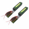 A pair of realistic cockroach prank gum toys with red bodies and green packaging.