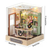 A miniature Japanese sakura tea house display featuring wooden furniture and jewelry items with an LED light.