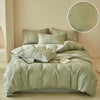A light sage green microfiber duvet cover set with an embossed leaf pattern displayed on a bed.