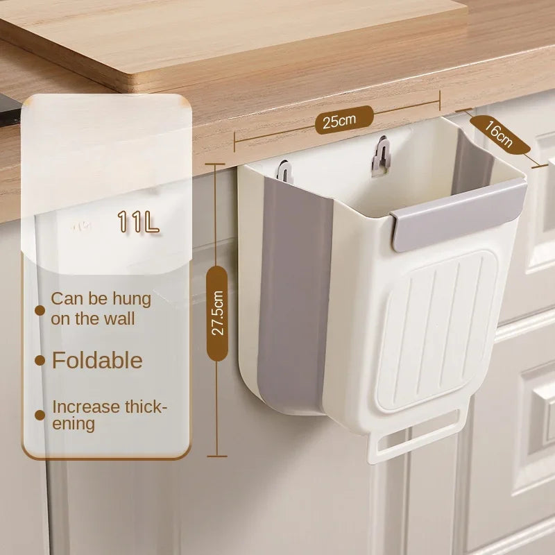 Weißer faltbarer Küchen- und Campingmülleimer hängt an einem Holzschrank mit Markierungen.