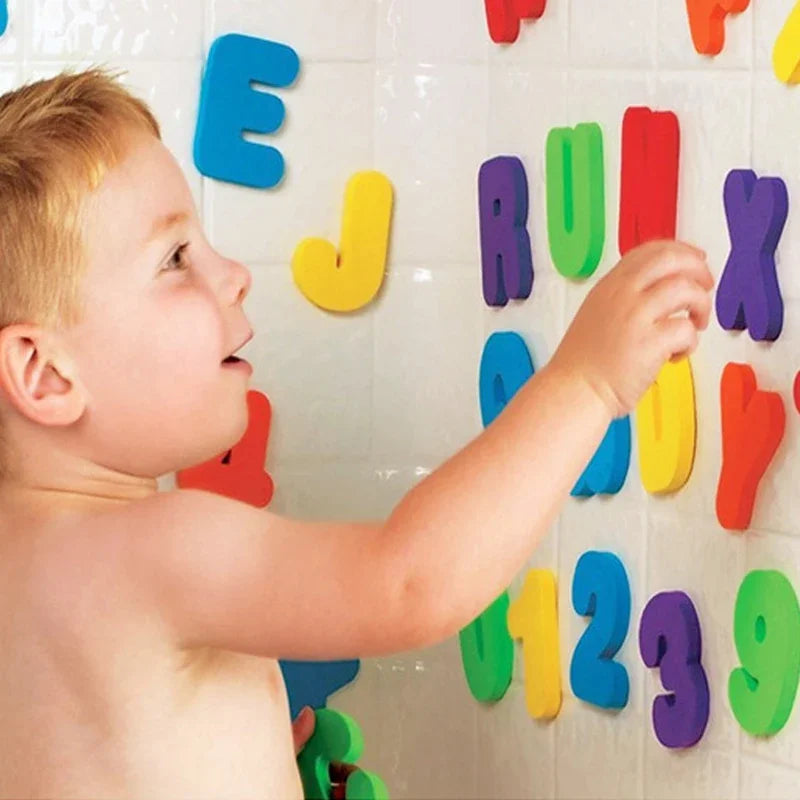 A toddler is interacting with a wall display of colorful EVA bath letters and numbers.
