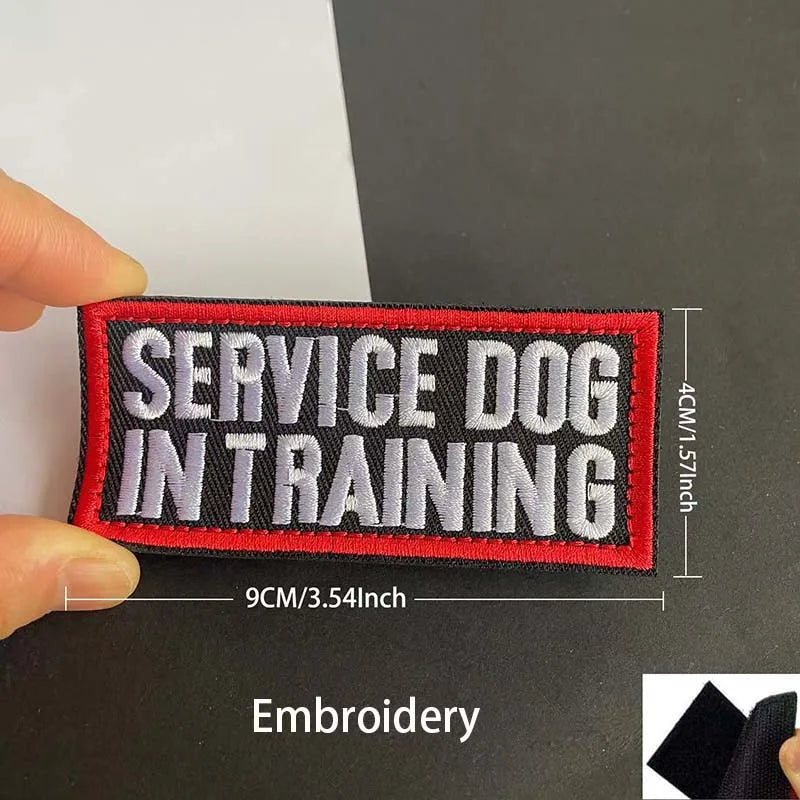 A black embroidered patch with red lettering that reads SERVICE DOG IN TRAINING