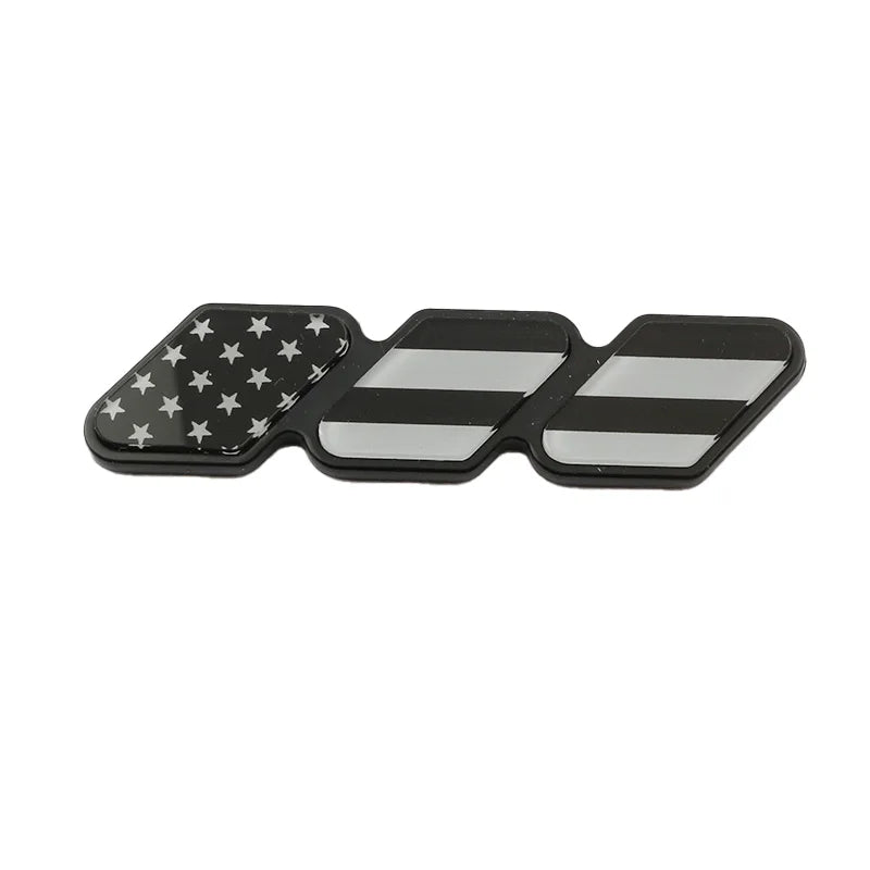 A set of three 3D tri-color grille emblem stickers featuring American flags and black and white stripes.
