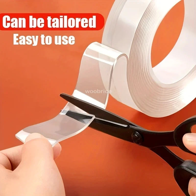 A hand is using a black tool to tailor or cut a roll of clear double-sided adhesive tape.