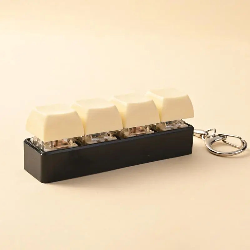 A black LED mechanical keychain fidget toy with custom keycaps and several white silicone pieces.