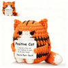 An orange crocheted cat figurine with black stripes and a card that reads Positive Cat You're Purr-fect