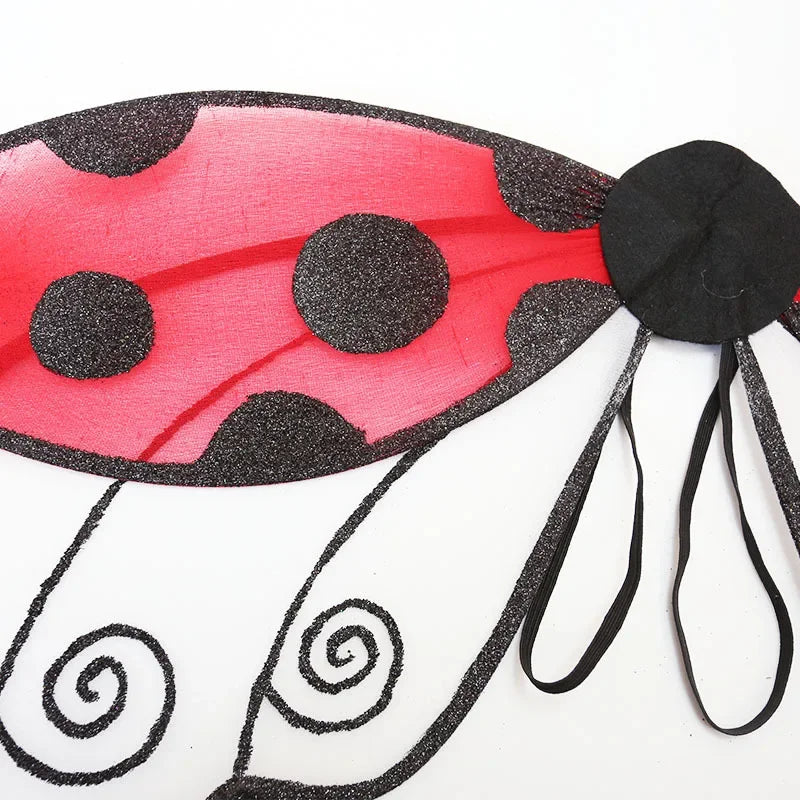 A red ladybug wing costume featuring black polka dots and swirling black lines.