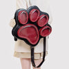 Black backpack with a cat paw print design featuring multiple red velvet pockets and a black strap.