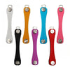 A collection of eight aluminum key clips with carabiner hooks in various colors including silver, orange, blue, purple, and r