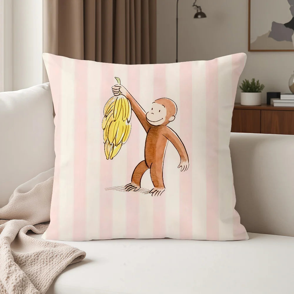 A pink striped pillow featuring a cartoon monkey character holding a banana.