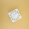 A white dial or gauge with a red indicator pointing near the 10 mark on a light beige background.