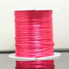 A spool of bright pink elastic cord used for beading and jewelry making.