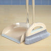 A beige broom and dustpan set with a floor wiper resting on a light wooden surface.