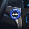 A close-up of a blue rotating protective cover for a car ignition start button featuring a black bat logo.