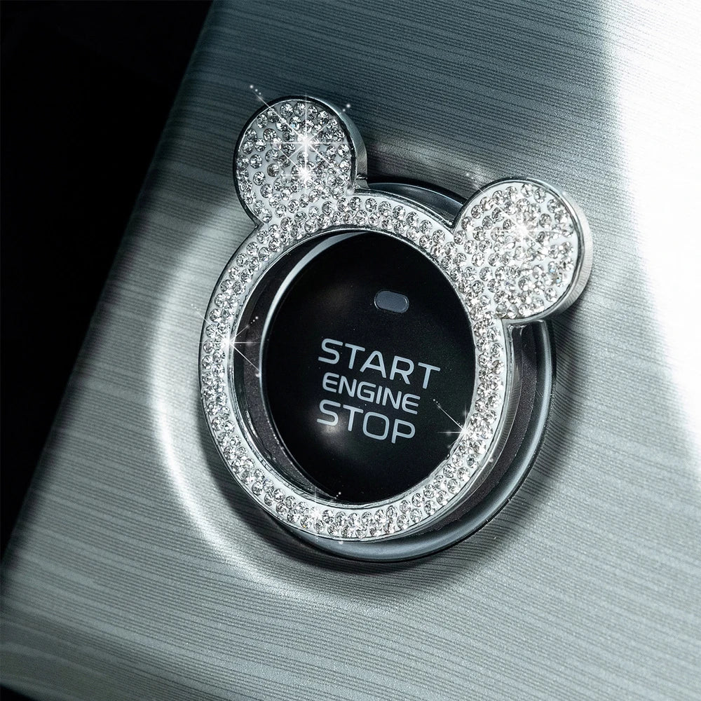 A close-up of a crystal rhinestone ignition button ring featuring a Mickey Mouse design on a silver surface.