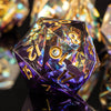 A purple resin polyhedral die is shown reflecting light on a dark surface.