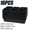 A stack of black modular drawer organizer trays with interlocking dividers, including small, medium, and large sizes.