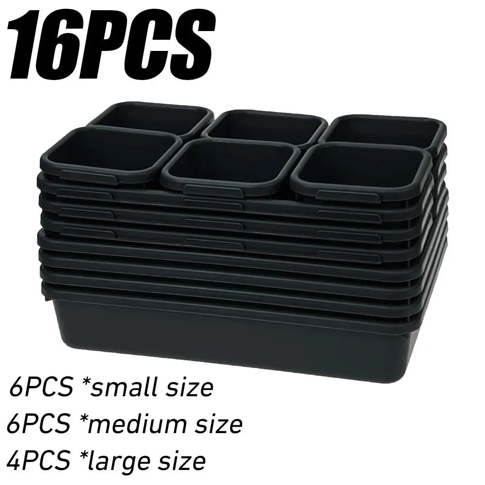 A stack of black modular drawer organizer trays with interlocking dividers, including small, medium, and large sizes.