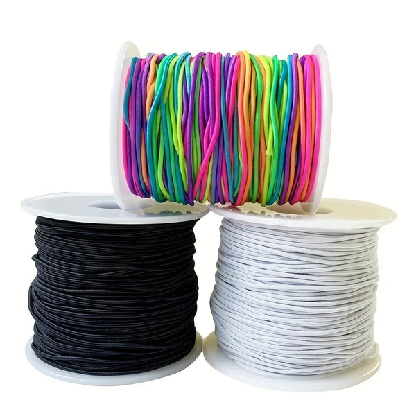 Spools of brightly colored stretchy elastic cord for jewelry making, including rainbow colors and solid black and white.
