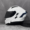A white modular flip-up motorcycle helmet is displayed on a gray surface.
