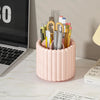 A pink cylindrical organizer holds various makeup brushes and tools for organization.